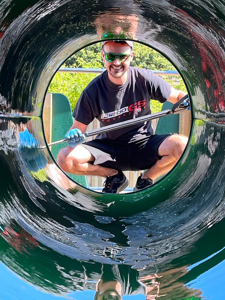 Facilities Team member Rob Eddy looking through a playground tunnel