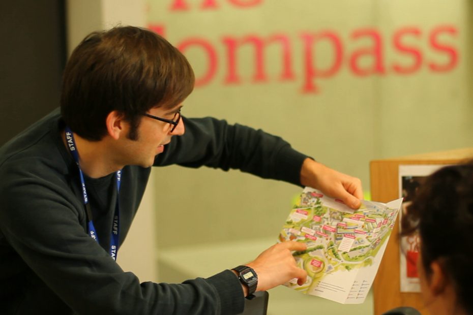 Man helping a student by pointing at map