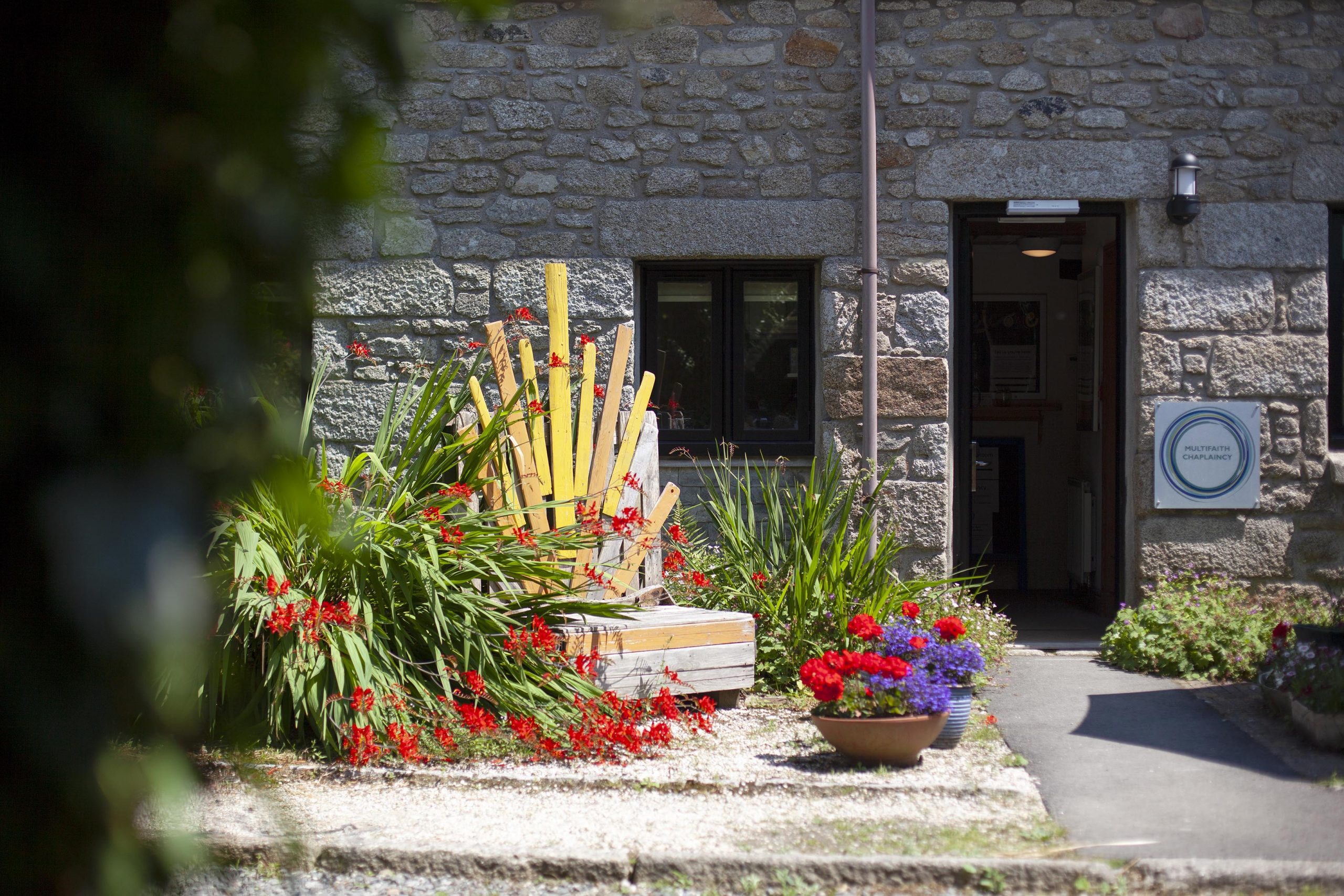 Entrance to chaplaincy at Penryn campus with bench and plants outside