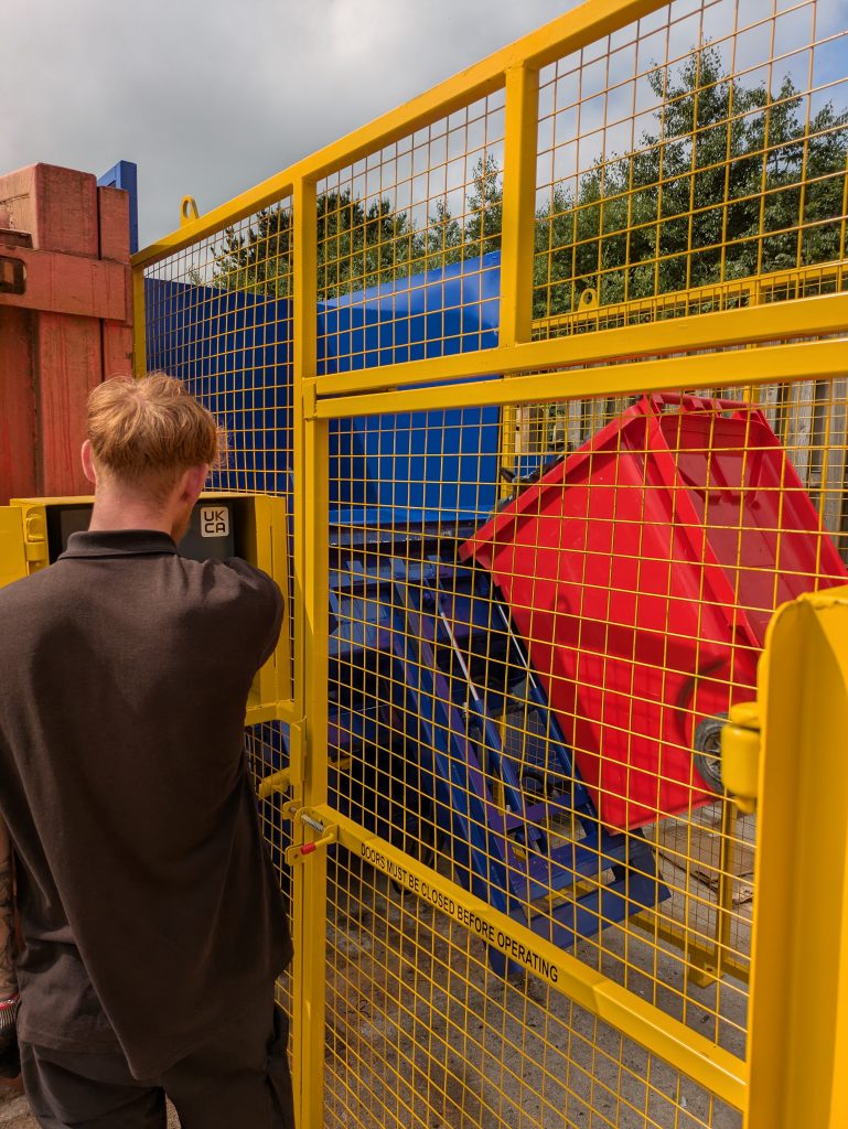 A hardworking FX Pus employee operating the new waste compactors in the waste compound.